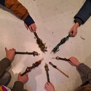 Kinder halten Bernstein- und Heilsteine in den Händen, umgeben von Naturmaterialien.